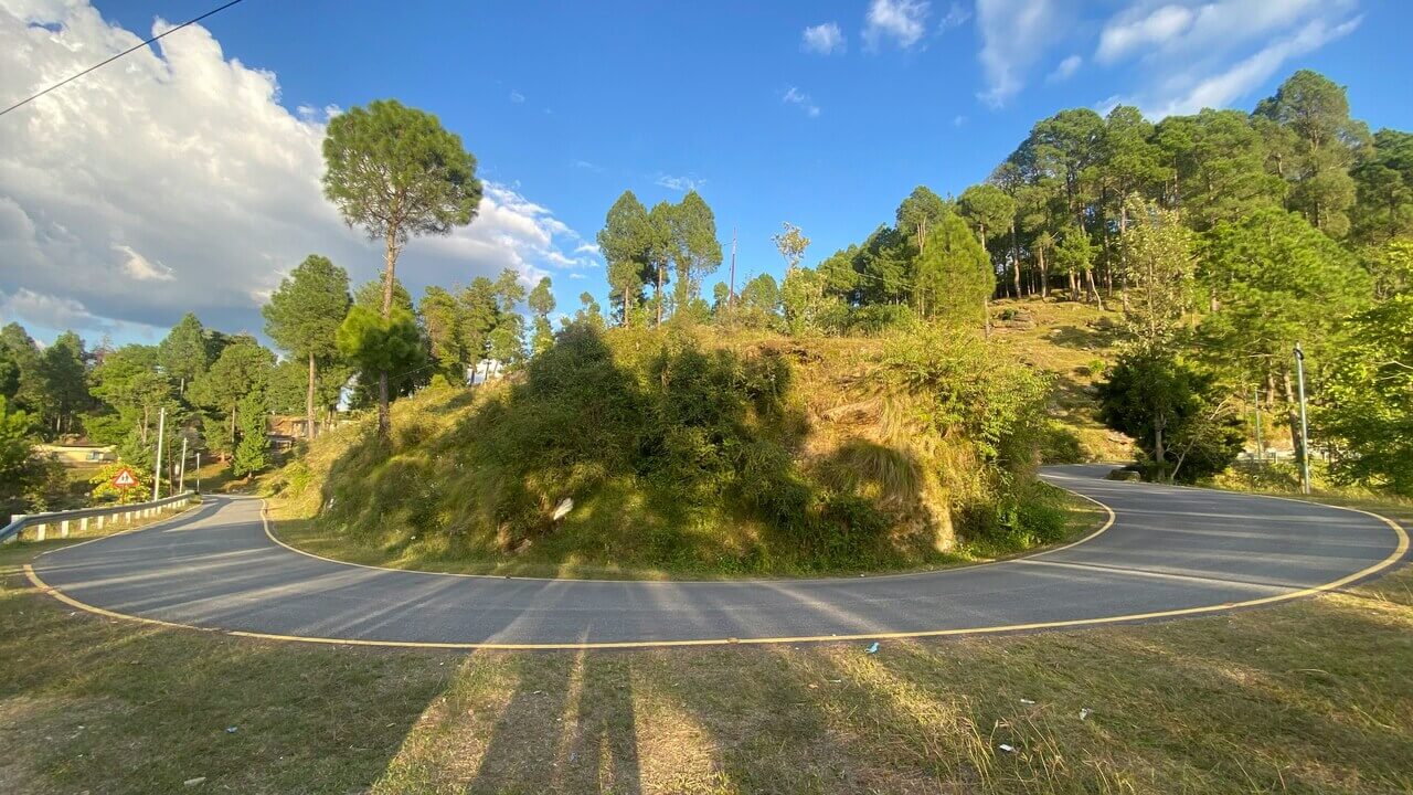 curved road going through the hills of almora