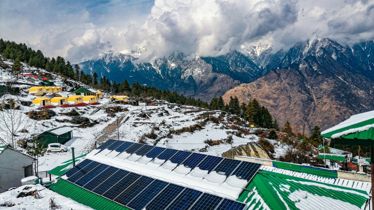 small tents along the slope of snow covered mountain in auli