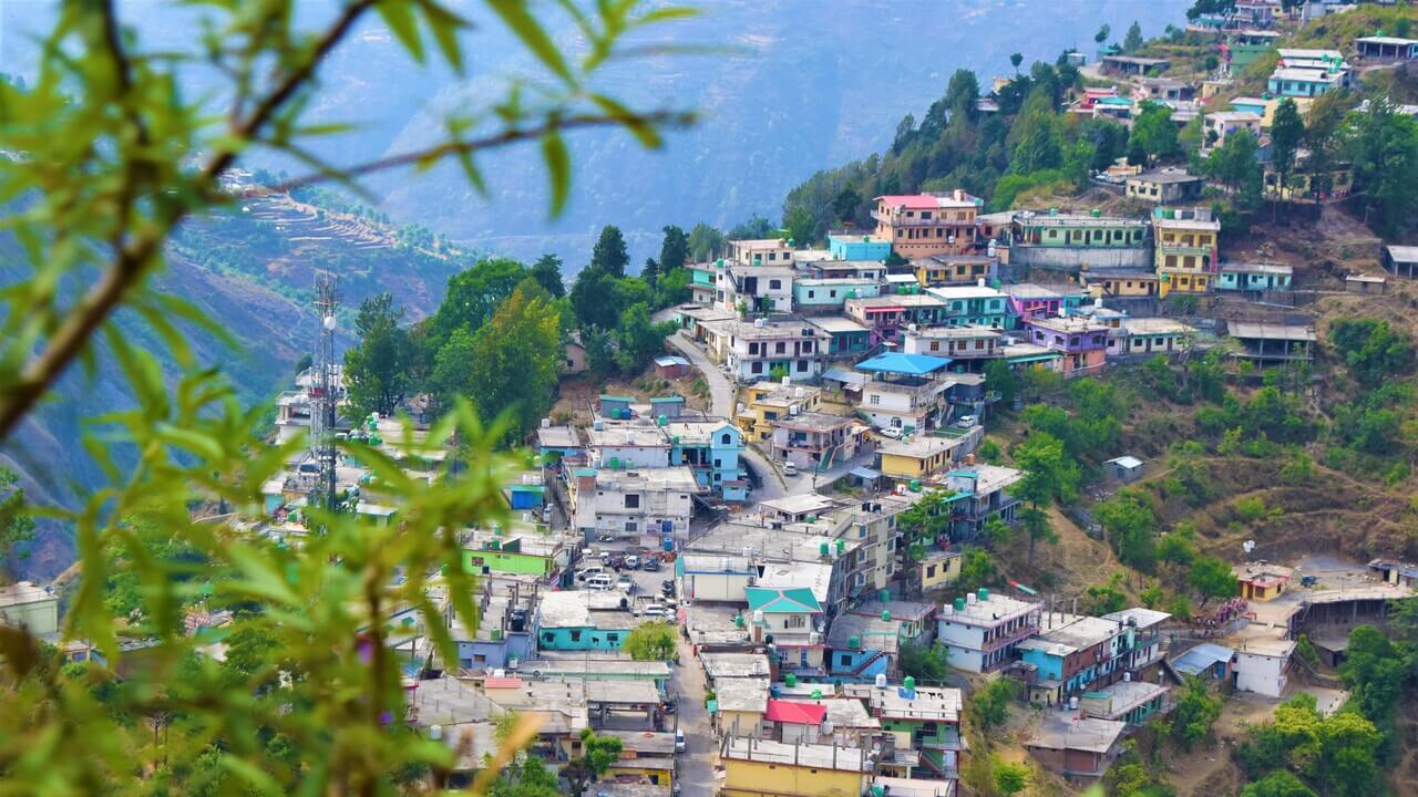 colorful houses situated along the edge of a hill in mussoorie