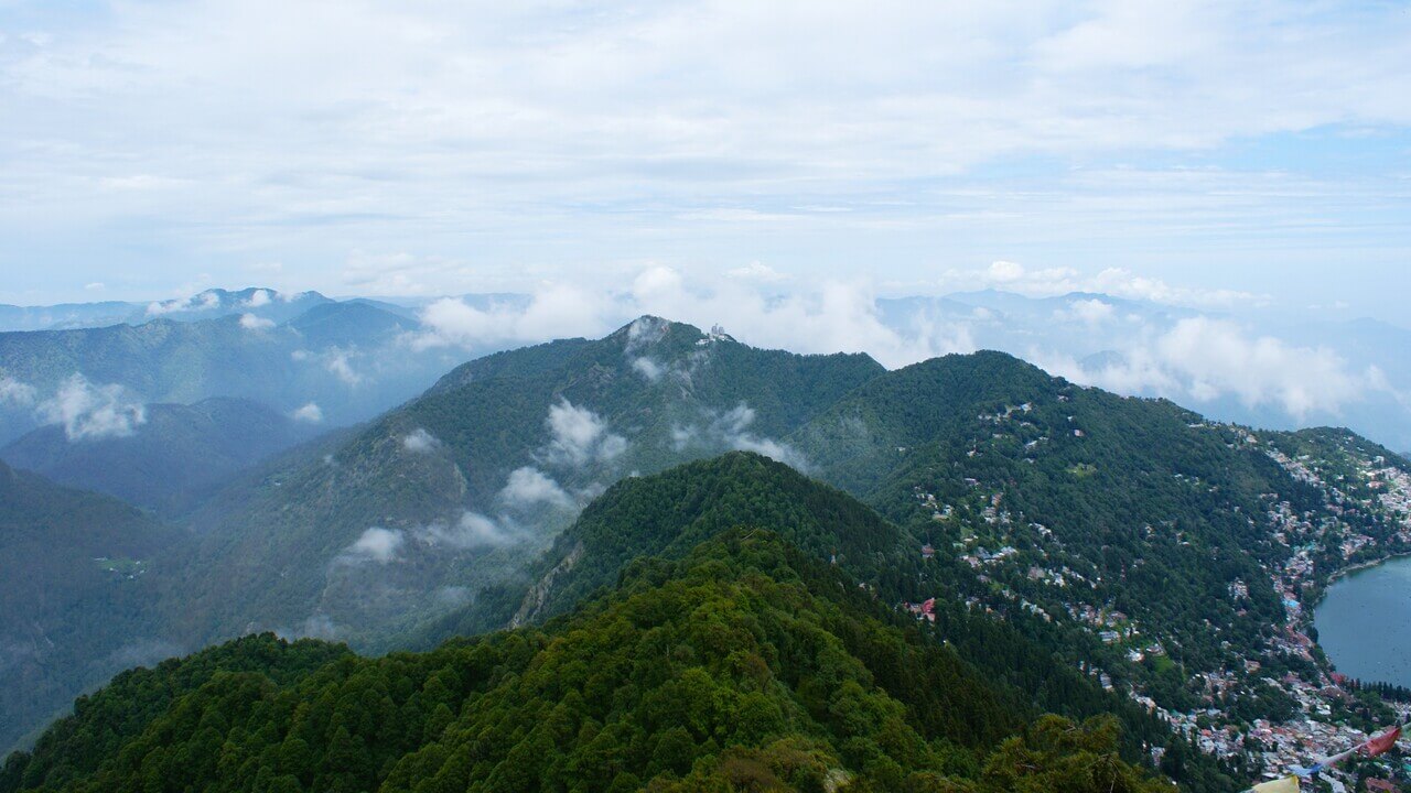 clouds floating over mountains covered with trees