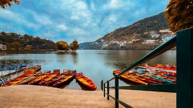 view of nainital lake with boats lined up along the edge of lake