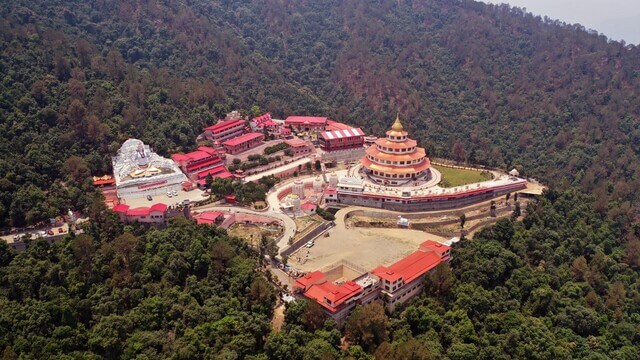 large temple surrounded by trees in rishikesh